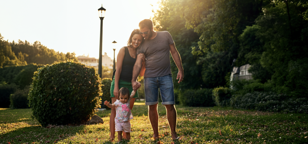 Couple with a young child walking in the park